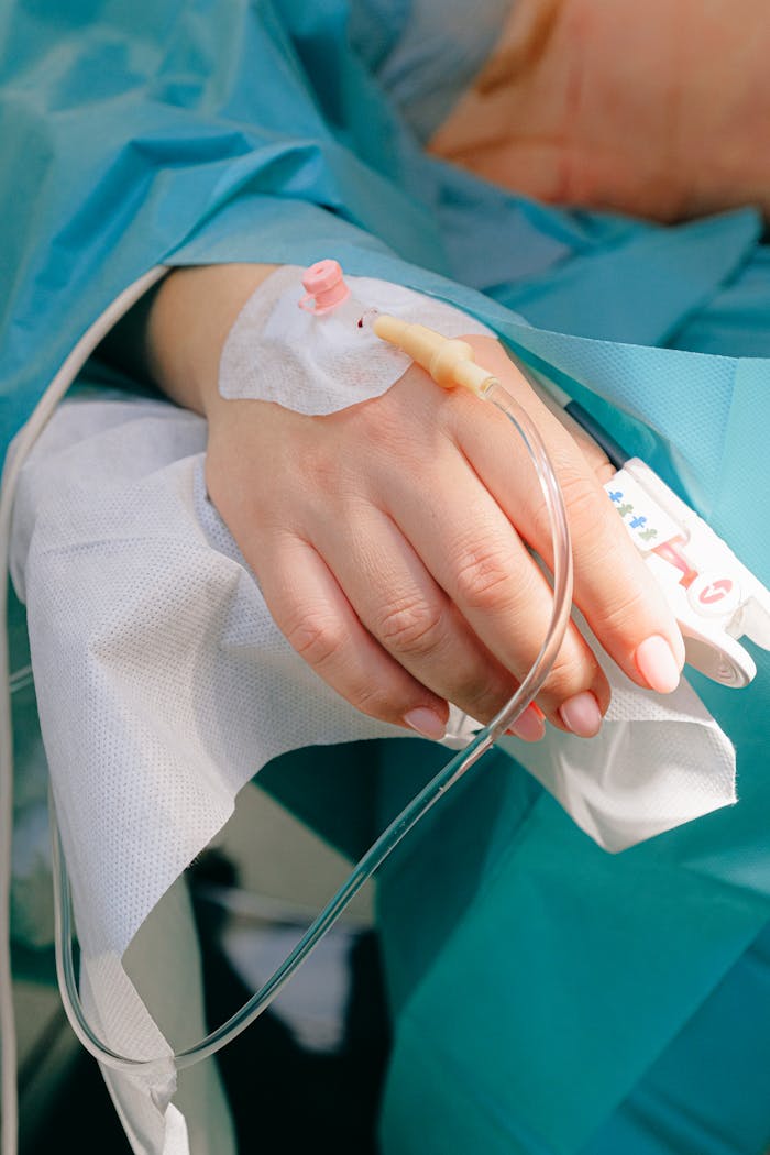 Close-up of a patients hand receiving intravenous therapy in a hospital setting.